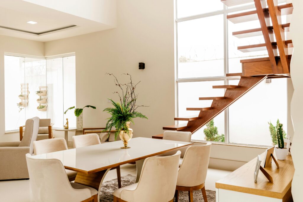Premium Flat VS Duplex Interior of light living room with wooden stairs and table with comfortable chairs in contemporary house